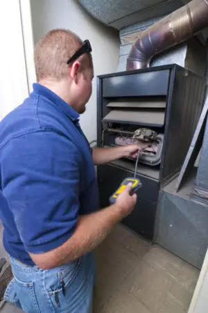Air Comfort Technologies technician inspecting furnace for combustion leak in York County PA