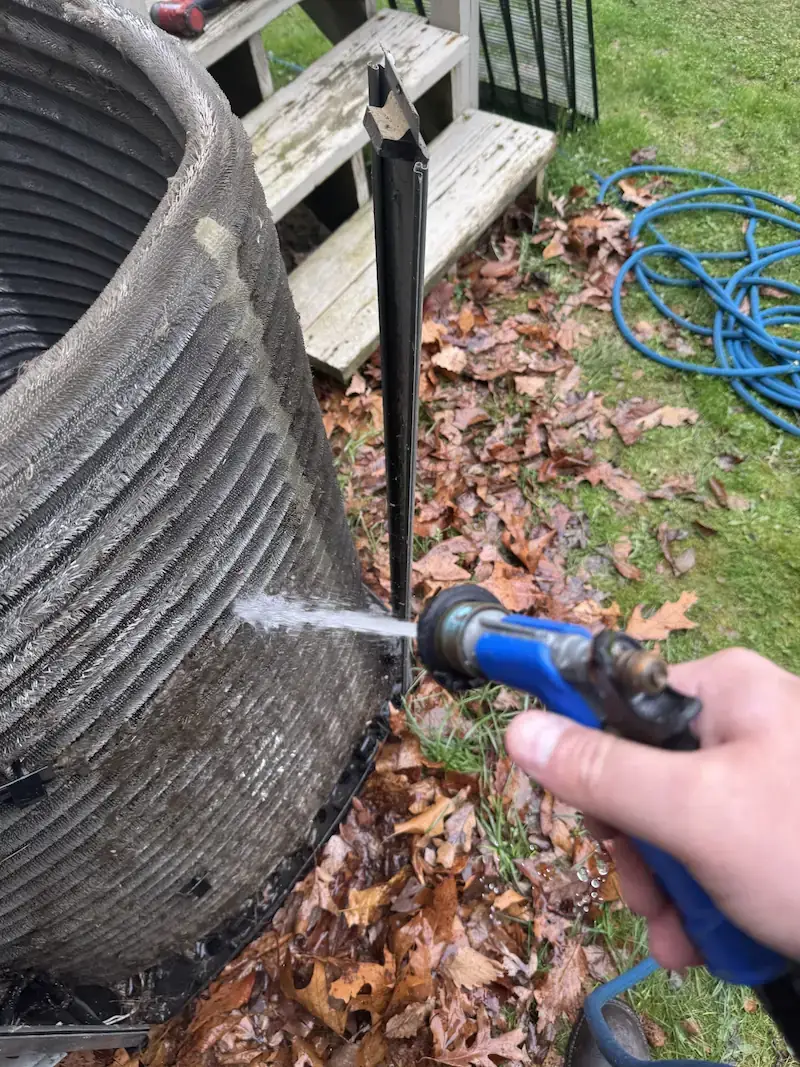 Technician cleaning an outdoor condenser coil during a tune-up